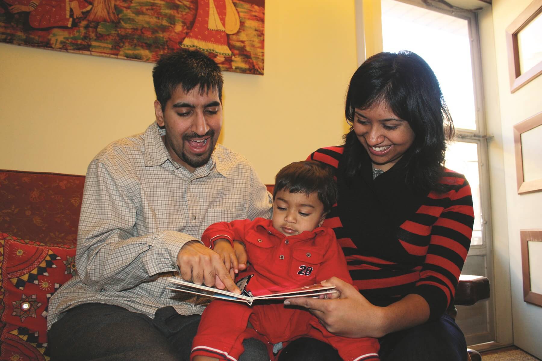 Parents reading a book to toddler